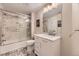 Well-lit bathroom with a glass-enclosed shower-tub, modern vanity, and elegant finishes at 8778 S Quatar St, Aurora, CO 80016