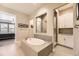 Luxurious bathroom featuring soaking tub, separate shower, white cabinets, and access to the main bedroom at 8778 S Quatar St, Aurora, CO 80016