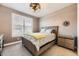 Comfortable bedroom with wood bed frame, modern ceiling fan, and plantation shutters at 8778 S Quatar St, Aurora, CO 80016