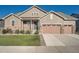 Charming two-story home featuring a manicured lawn, stone accents, and a two-car garage at 8778 S Quatar St, Aurora, CO 80016