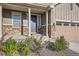 Inviting front entrance with stone accents, manicured landscaping, and a covered porch at 8778 S Quatar St, Aurora, CO 80016