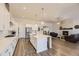 Bright, open kitchen featuring a large island, white cabinets, stainless steel appliances, and a seamless transition to the living area at 8778 S Quatar St, Aurora, CO 80016