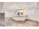 Open-concept living room with hardwood floors, a kitchen island and plenty of natural light at 8778 S Quatar St, Aurora, CO 80016