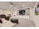 Inviting living room with plush seating, a large screen TV, and built in cabinets for storage at 8778 S Quatar St, Aurora, CO 80016