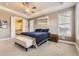 Spacious main bedroom featuring tray ceiling, ceiling fan, plantation shutters, ensuite access, and king bed at 8778 S Quatar St, Aurora, CO 80016