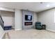 Finished basement showcases electric fireplace, mounted TV, and plush green chair creating a cozy retreat at 6488 S Kewaunee Way, Aurora, CO 80016