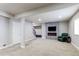 Finished basement with stairs, an electric fireplace, mounted TV, and plush green chair creates a cozy retreat at 6488 S Kewaunee Way, Aurora, CO 80016