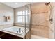 Bright bathroom featuring a soaking tub and a glass enclosed shower with a built-in bench at 6488 S Kewaunee Way, Aurora, CO 80016