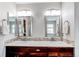 Bright bathroom features dual vanity with two sinks, decorative mirrors, and modern fixtures at 6488 S Kewaunee Way, Aurora, CO 80016