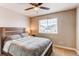 Cozy bedroom with a plush bed, bedside lamp, neutral colors and large window at 6488 S Kewaunee Way, Aurora, CO 80016