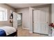 Comfortable bedroom featuring closet with sliding doors, a window, and a view to another room at 6488 S Kewaunee Way, Aurora, CO 80016