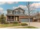 Charming two-story home with a well-manicured lawn, a yellow front door, and a three-car garage at 6488 S Kewaunee Way, Aurora, CO 80016