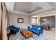 Open-concept living room with a coffered ceiling, a wood table, and access to dining area at 6488 S Kewaunee Way, Aurora, CO 80016