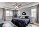 Main bedroom with a tray ceiling, two windows, and a gray decorative finish at 6488 S Kewaunee Way, Aurora, CO 80016