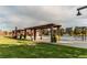 Community pool area with wooden pergolas, lush landscaping, and relaxing atmosphere at 6488 S Kewaunee Way, Aurora, CO 80016
