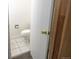 Powder room with white toilet and tiled floor viewed through the doorway at 8746 Mariposa St, Thornton, CO 80260