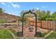 Backyard with metal garden archway, fire pit, and landscaped tiers at 7466 E Long Cir, Centennial, CO 80112