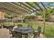 Relaxing backyard patio features a pergola, a patio table, and green lawn at 7466 E Long Cir, Centennial, CO 80112