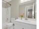 Cozy bathroom featuring white fixtures, a shower-tub combo, and a large mirror at 7466 E Long Cir, Centennial, CO 80112