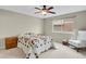 Neutral-toned bedroom featuring a cozy bed, ceiling fan, and window allowing natural light at 7466 E Long Cir, Centennial, CO 80112