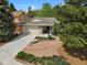 Aerial view of home with stone accents, front garden, and spacious driveway at 7466 E Long Cir, Centennial, CO 80112