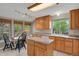 Traditional kitchen with oak cabinets, granite countertops, and an island, illuminated by natural light from large windows at 7466 E Long Cir, Centennial, CO 80112