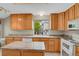 Bright kitchen featuring wooden cabinets, granite countertops, an island, and modern white appliances at 7466 E Long Cir, Centennial, CO 80112