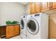 Efficient laundry room with modern washer and dryer, cabinet storage, and a convenient countertop at 10156 Nottingham Dr, Parker, CO 80134