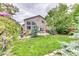Serene backyard with a lush lawn, mature trees, a patio area, and a fire pit for outdoor enjoyment and entertaining at 10191 Sagecrest St, Highlands Ranch, CO 80126