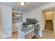 Bright home office with desk and shelving next to carpeted stairs at 10191 Sagecrest St, Highlands Ranch, CO 80126
