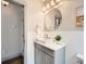 Chic half-bathroom featuring a stylish vanity, oval mirror, and neutral decor at 3833 Umatilla St, Denver, CO 80211