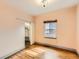 Cozy bedroom featuring hardwood floors, natural light from a window, and built-in closet at 3833 Umatilla St, Denver, CO 80211