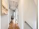 Hallway with hardwood floors and views into other rooms in a neutral color palette at 3833 Umatilla St, Denver, CO 80211