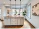 Sunlit kitchen island with pendant lights, stylish decor, and hardwood flooring at 3833 Umatilla St, Denver, CO 80211