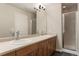 Bathroom featuring double sinks, a large mirror, and a glass-enclosed shower at 8571 Gold Peak Dr # C, Highlands Ranch, CO 80130