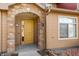 Charming front entrance with a stone archway, painted yellow door, and clearly visible unit number at 8571 Gold Peak Dr # C, Highlands Ranch, CO 80130