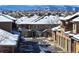 Street view of snow-covered townhomes with attached garages, in a well-maintained community on a sunny day at 8571 Gold Peak Dr # C, Highlands Ranch, CO 80130