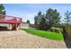 Backyard featuring a lawn, stone walkway, gravel, wood fence, patio, and elevated red deck with stairs at 16893 Trail View Cir, Parker, CO 80134