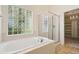 Bright bathroom featuring a soaking tub, glass block window, and a separate shower at 16893 Trail View Cir, Parker, CO 80134
