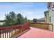 Outdoor deck with red railings and painted surface offering a view of surrounding trees and neighborhood at 16893 Trail View Cir, Parker, CO 80134