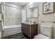 Stylish bathroom features sleek dark brown cabinetry, a granite countertop, and tiled walls at 410 Acoma St # 518, Denver, CO 80204