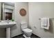 Stylish half bath with sleek black tile flooring and pedestal sink at 410 Acoma St # 518, Denver, CO 80204