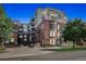 Modern exterior showcases Watermark building with brick and stucco elements, complemented by lush greenery, and updated streetscape at 410 Acoma St # 518, Denver, CO 80204