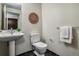 Elegant powder room with pedestal sink, modern fixtures, and black tiled flooring at 410 Acoma St # 518, Denver, CO 80204
