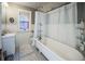 Charming bathroom featuring a clawfoot tub, white wainscoting and black and white tile flooring at 1351 N Franklin St, Denver, CO 80218