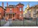 Striking red brick Victorian with turret, inviting front porch, and manicured front yard at 1351 N Franklin St, Denver, CO 80218