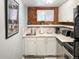 Compact kitchen boasts modern countertops, stainless steel appliances, and exposed brick accent wall at 1351 N Franklin St, Denver, CO 80218