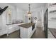 Spacious kitchen with an island, modern appliances, bright lighting, and access to a staircase at 1351 N Franklin St, Denver, CO 80218