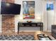 Living room with brick accent wall, sleek console table, and a modern city-themed art piece at 1351 N Franklin St, Denver, CO 80218