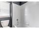 Bathroom with shower over tub and toilet with a white wall and grey paint at 10646 Amesbury Way, Highlands Ranch, CO 80126